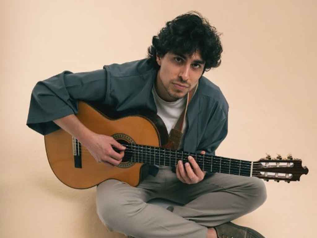 Andrés Iwasaki cantando en directo con guitarra en concierto íntimo